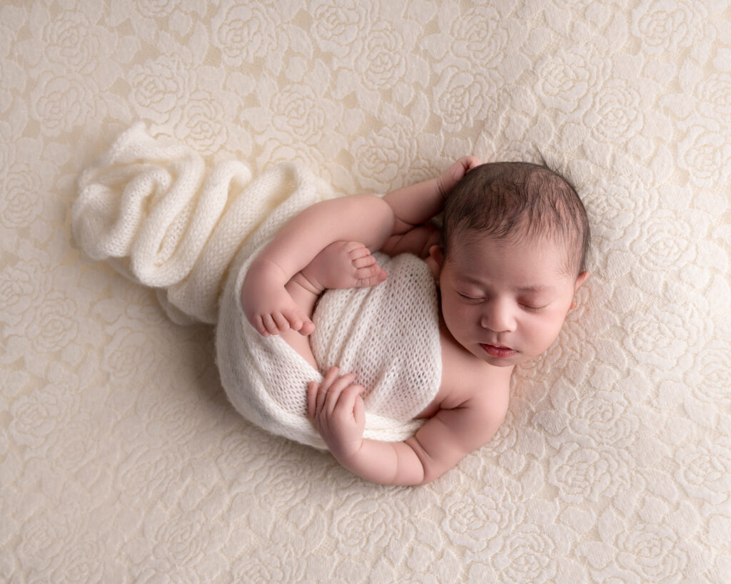 nyfødt jente fotografert hos fotograf gina englund med et mykt teppe rundt seg
