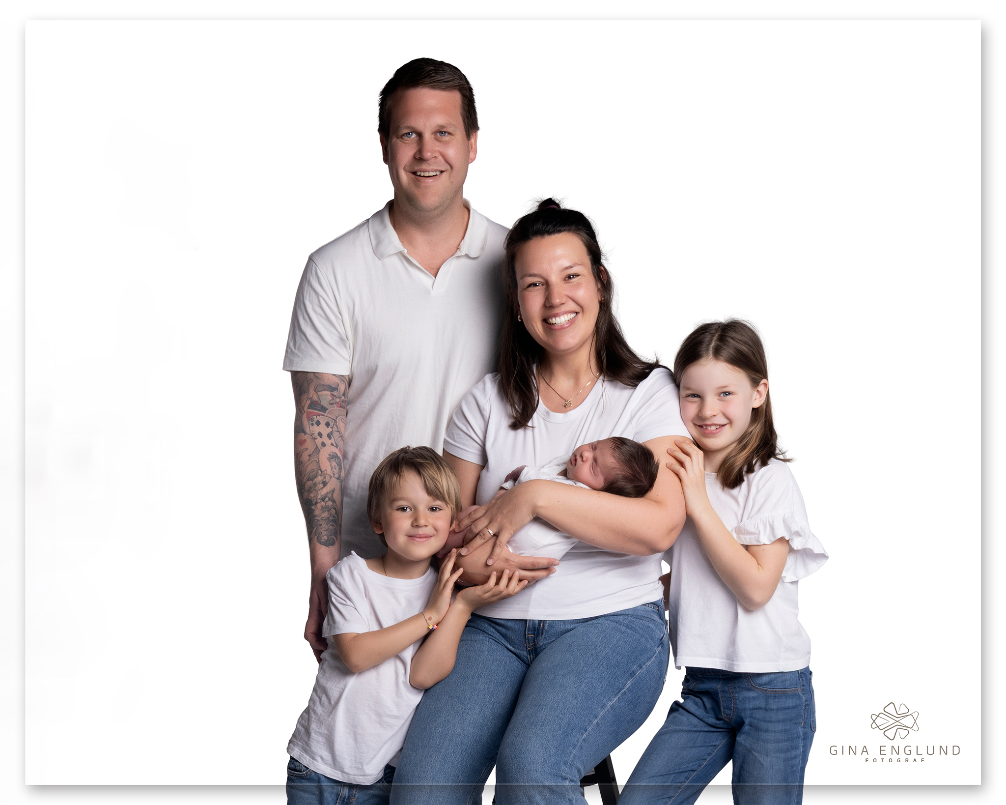 Familie med nyfødt baby fotografert i studio på Sofiemyr under nyfødtfotografering med foreldre og søsken.