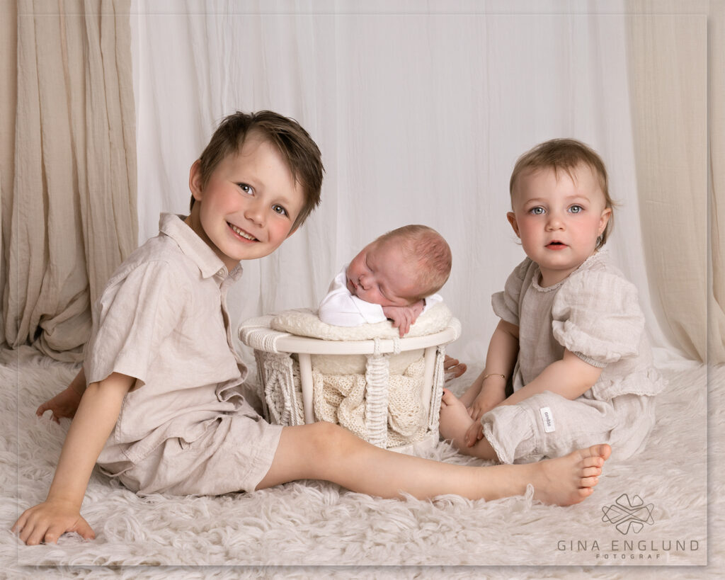 Nyfødtfotografering med søsken og nyfødt baby i studio på Sofiemyr. Tidløst søskenbilde fotografert av Gina Englund Fotograf i Nordre Follo.