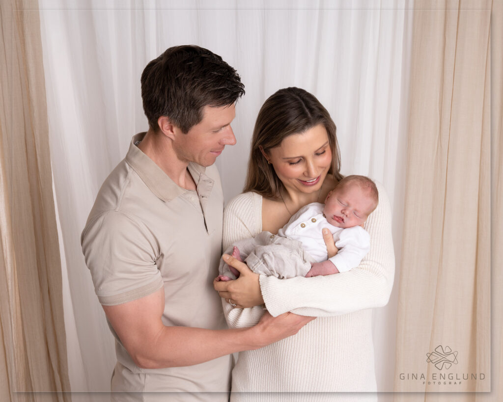 Nyfødtfotografering med foreldre og baby i studio på Sofiemyr. Tidløst familiebilde fotografert av Gina Englund Fotograf i Nordre Follo.

