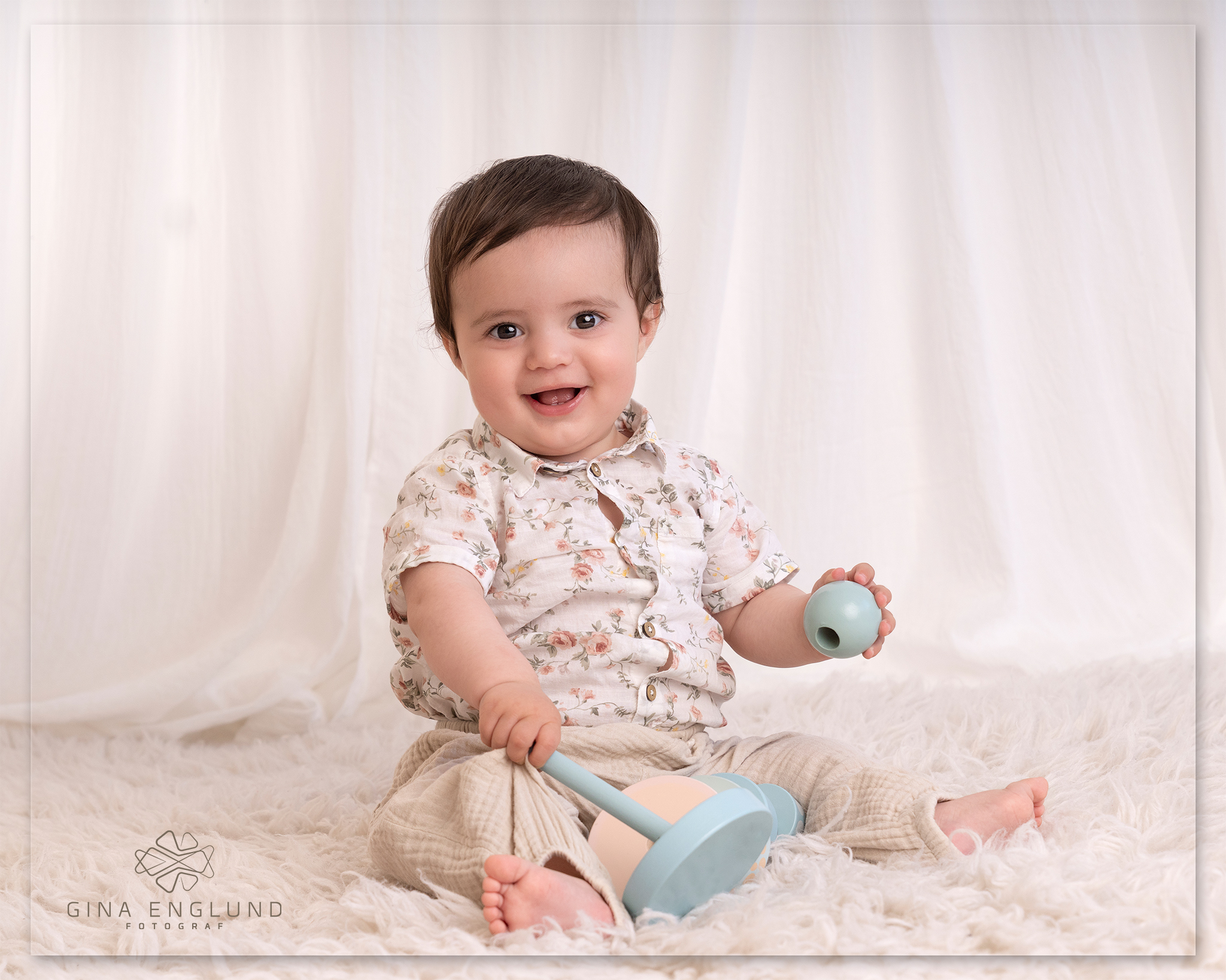 Smilende baby som leker under babyfotografering i studio på Sofiemyr.